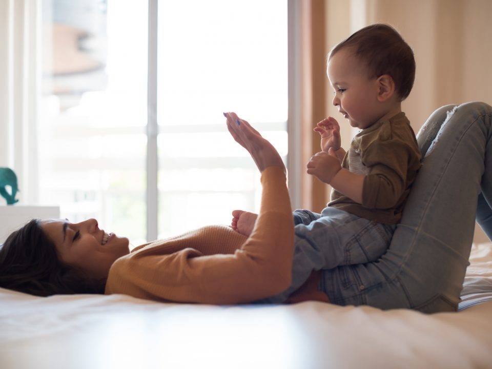 Mother playing patty cakes with her infant boy.